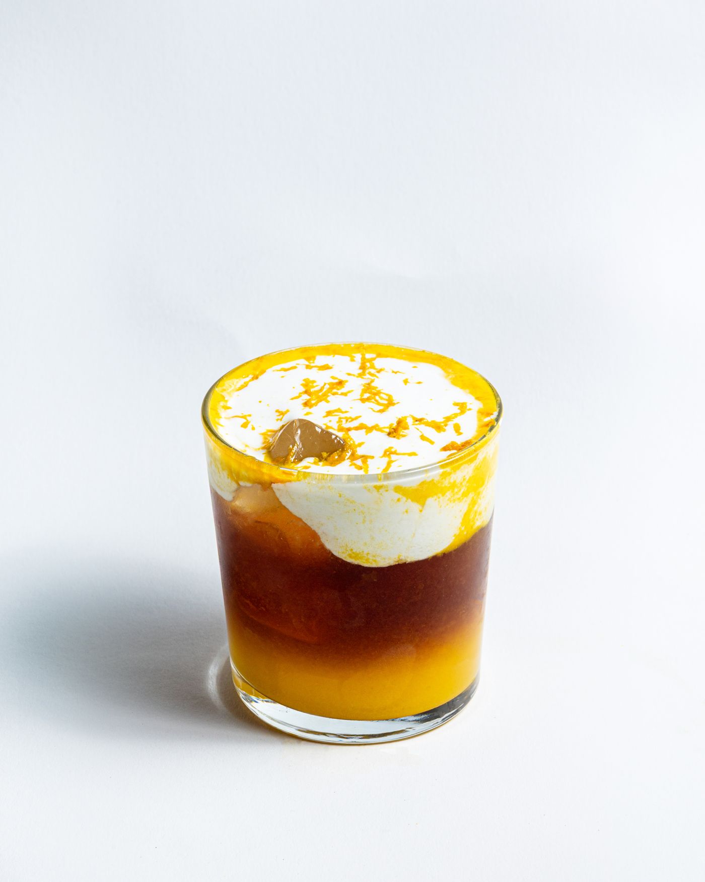 Kaltes Kaffeegetränk mit Orangenschale und Sahnehaube